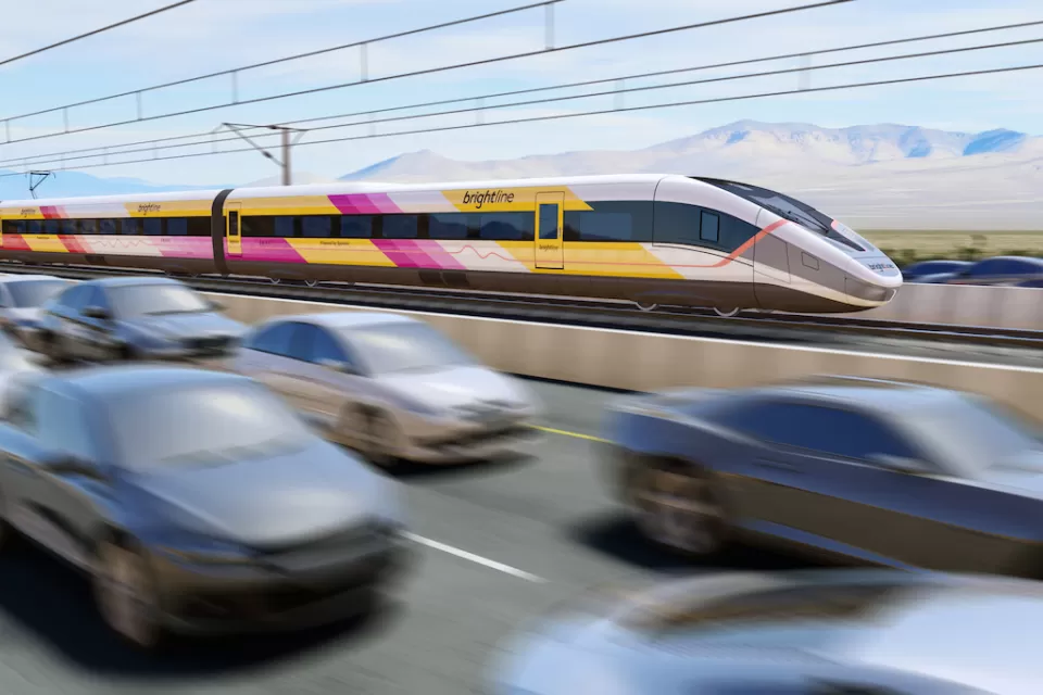 Rendering of white, yellow, and purple Brightline West high-speed rail train speeding along highway median with blurred cars in foreground.